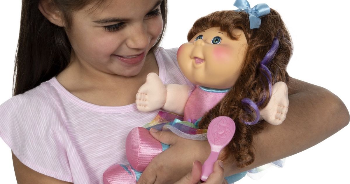 young girl holding a Cabbage Patch Kids Toddler dolls Style ‘N Play
