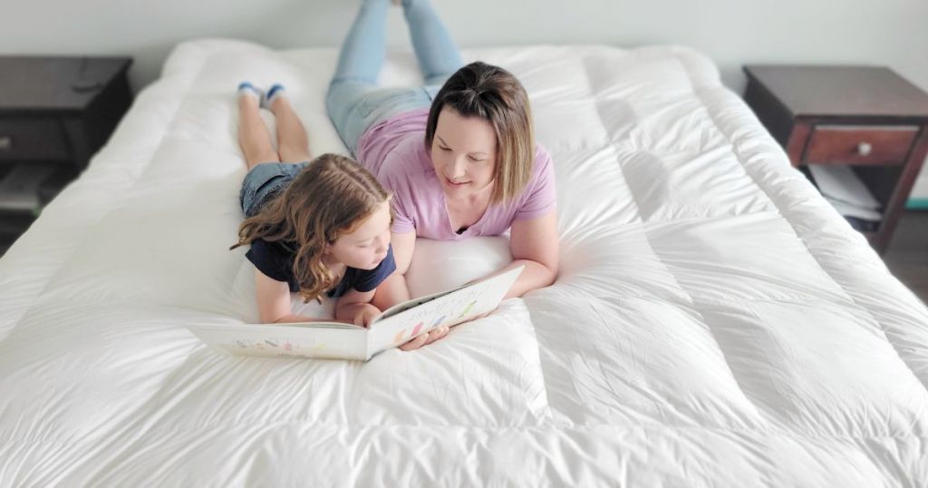 woman and child laying on ELEMUSE Extra Thick Cooling Mattress Topper reading a book