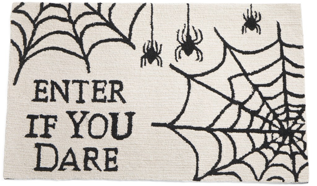 white spider web rug that says enter if you dare