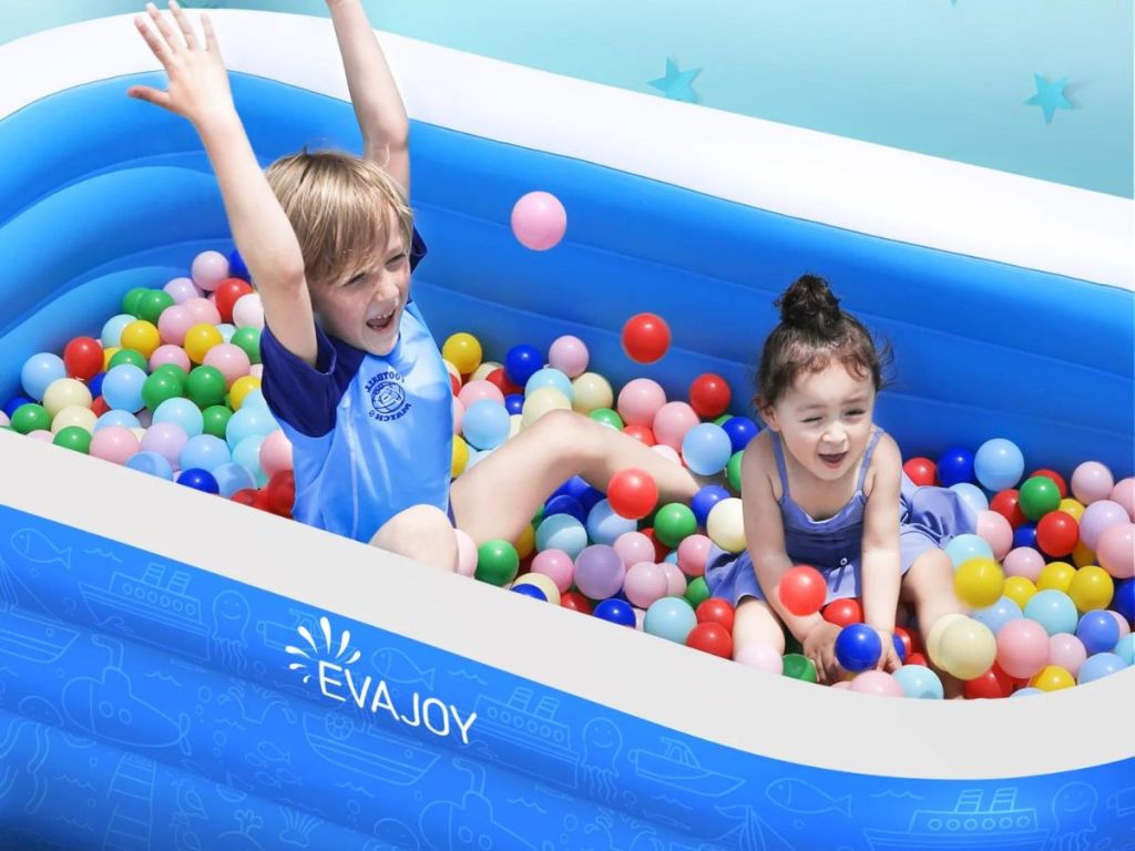 2 kids in inflatable pool filled with plastic balls