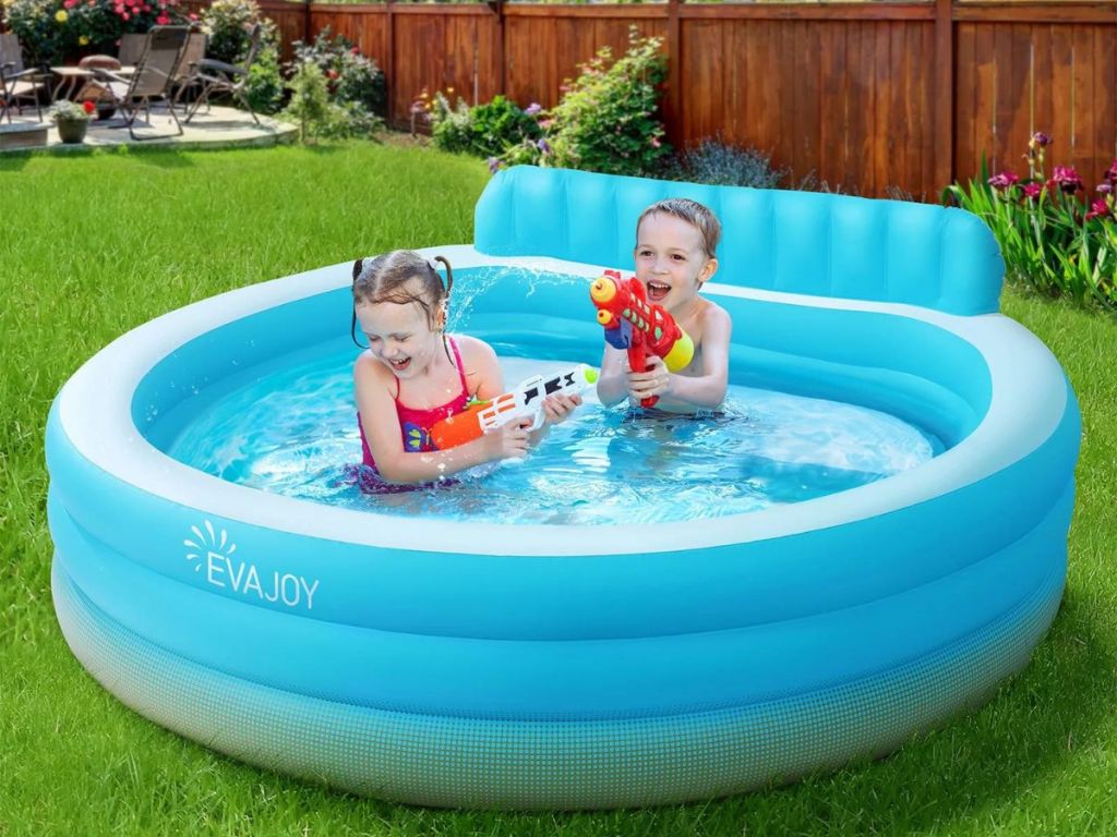2 kids with water toys in inflatable pool outside