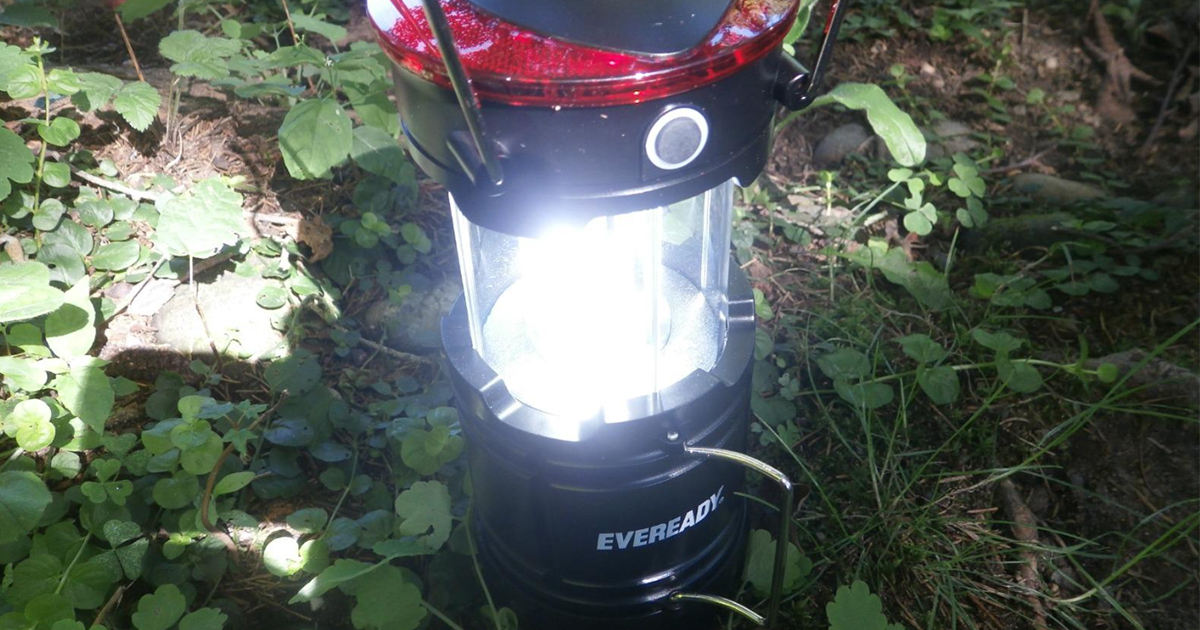 illuminated Eveready Lantern outside on the dirt and weeds