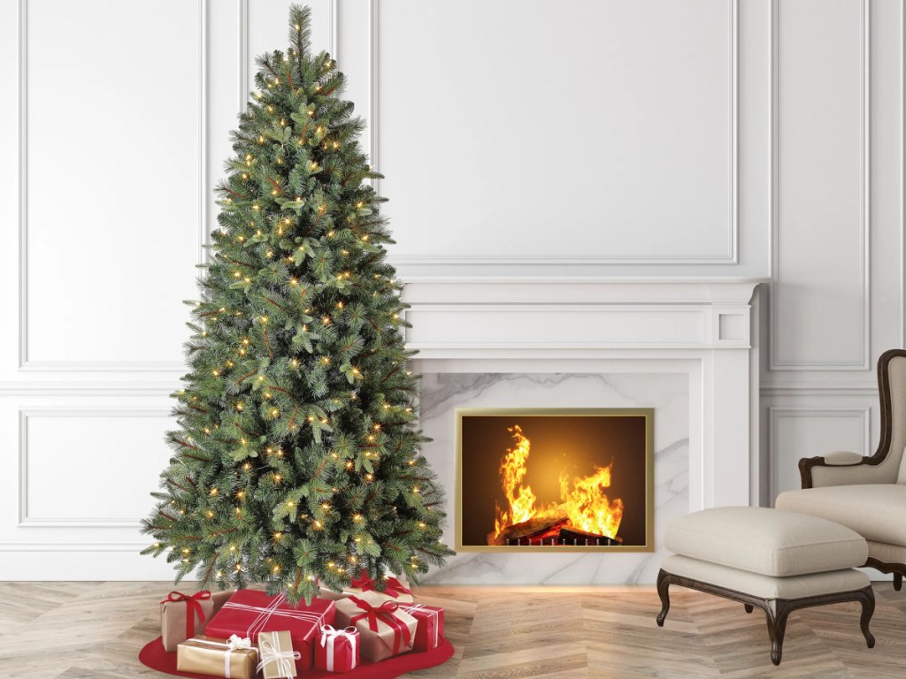 large Christmas tree with presents underneath by fireplace