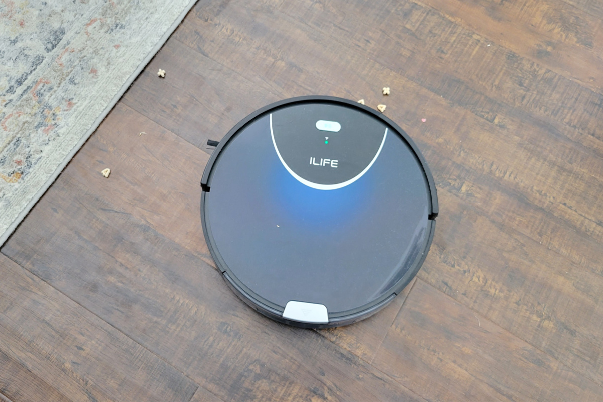ILIFE Robot Vacuum cleaning popcorn from a hardwood floor