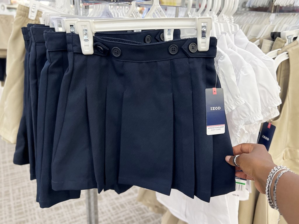 hand touching navy blue uniform skirt