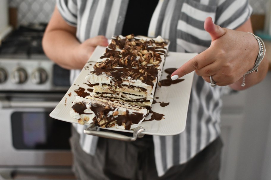 woman pointing to an Ice Cream Sandwich cake made from ice cream sandwiches