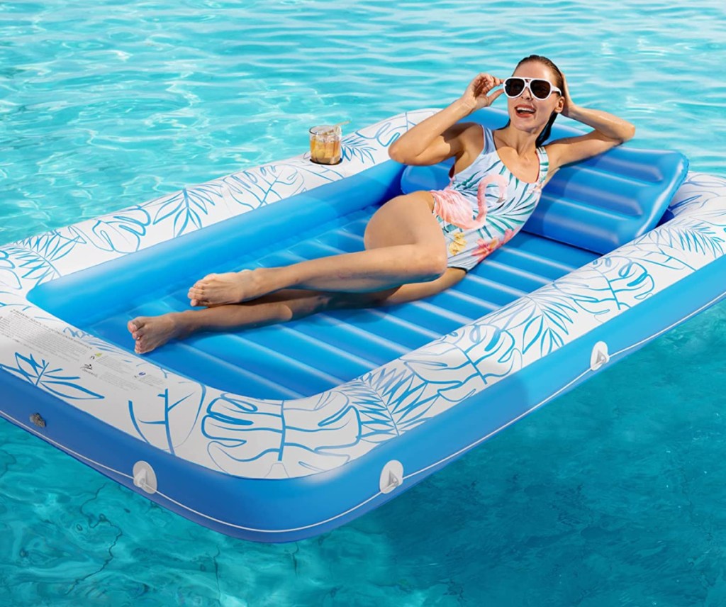 Woman sunbathing on an inflatable tanning pool lounger that is one of the top pool floats on Amazon