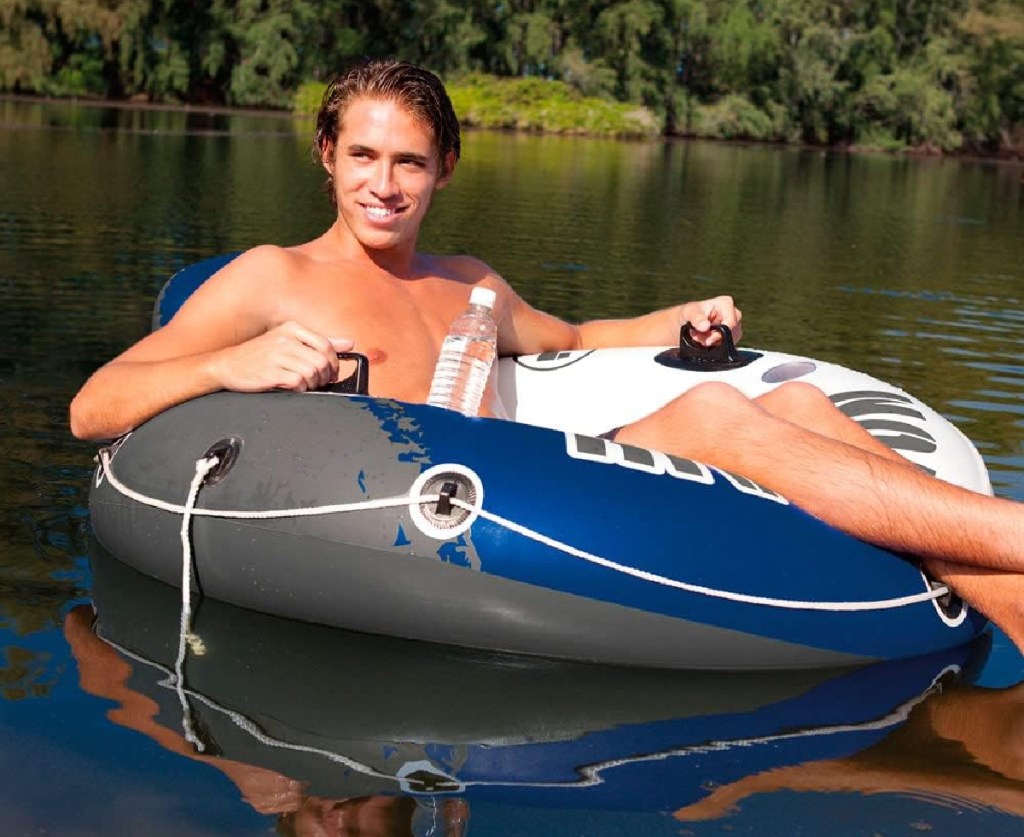 A man sitting in an Intex River Run Doughnut Style Pool Float which is a best selling pool float on Amazon
