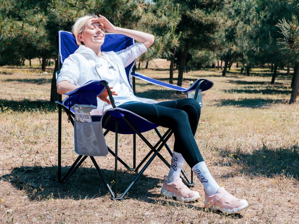 woman sitting in large camping chair outside