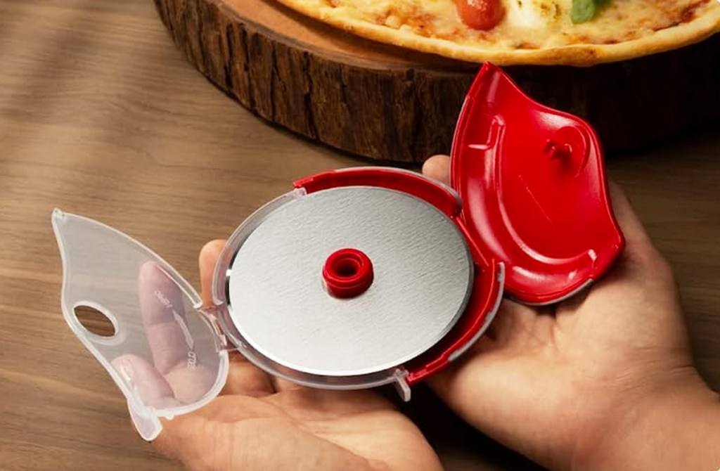 hands holding opened pizza cutter wheel