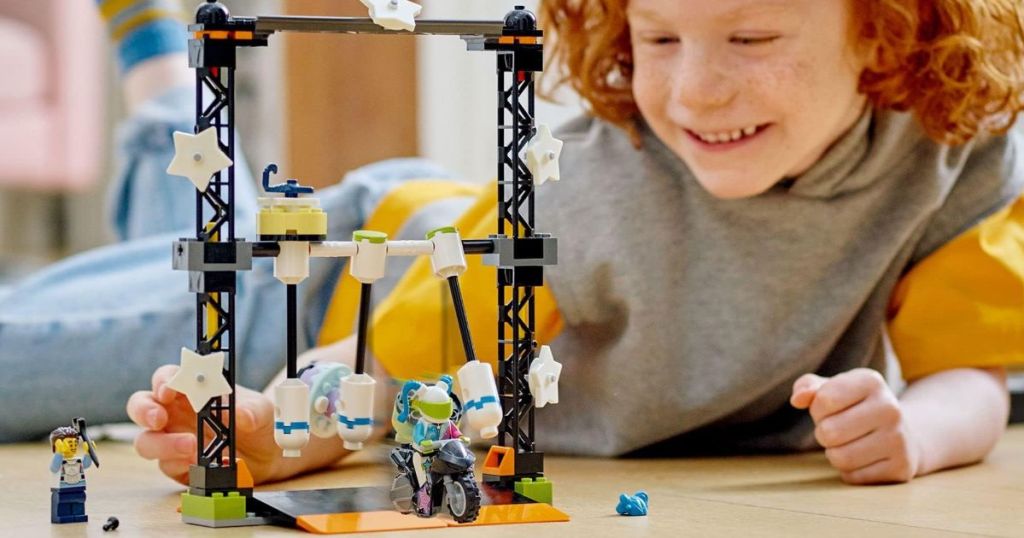 A child playing with LEGO cars