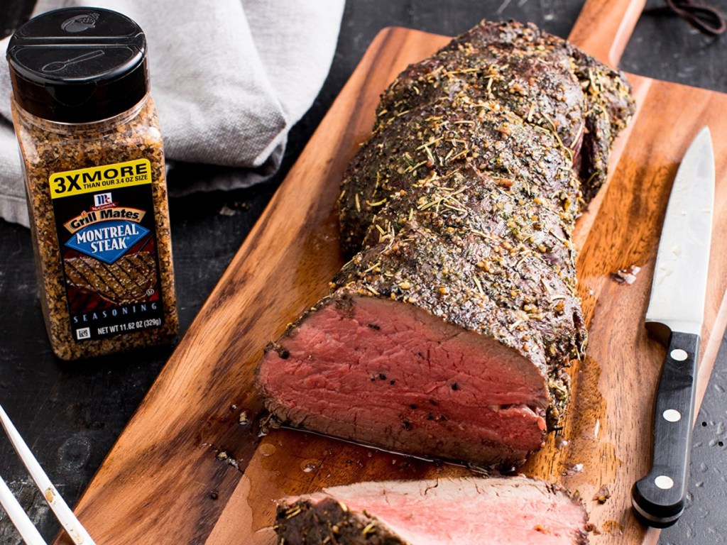 bottle of steak seasoning and cooked steak on cutting board