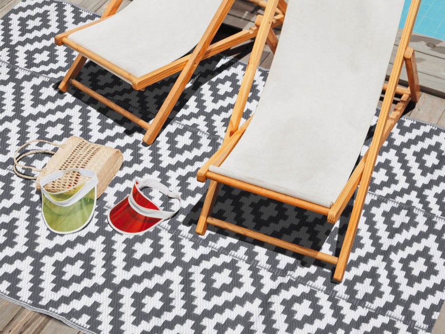 grey and white geometric area rug with wood chairs on top