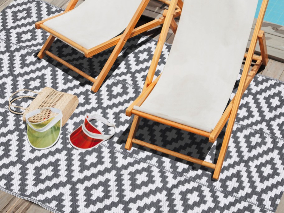 grey and white geometric area rug with wood chairs on top