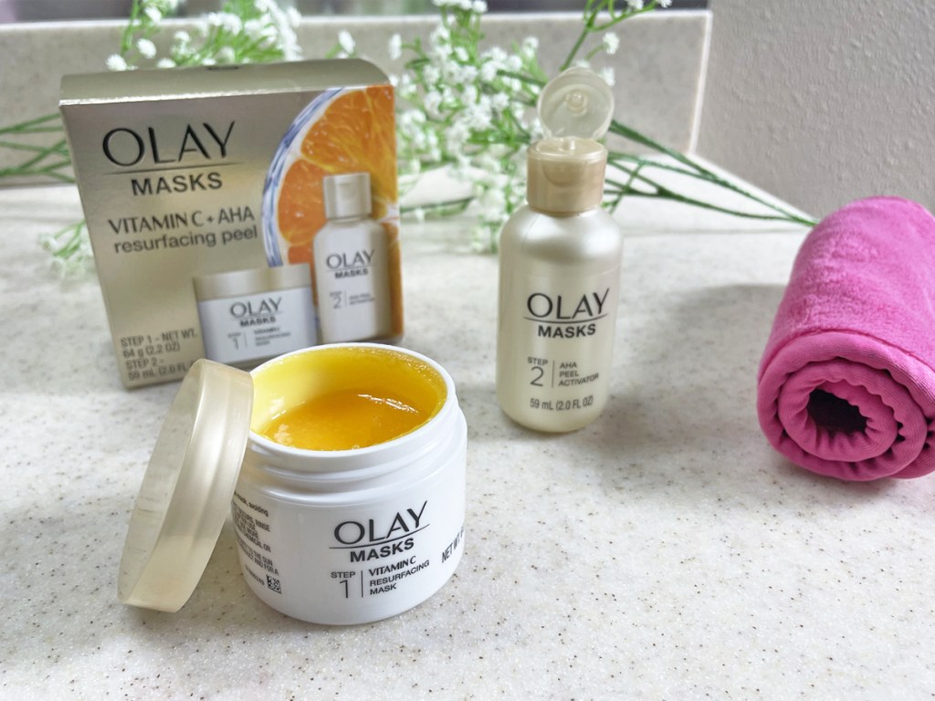 olay masks set on counter with flowers