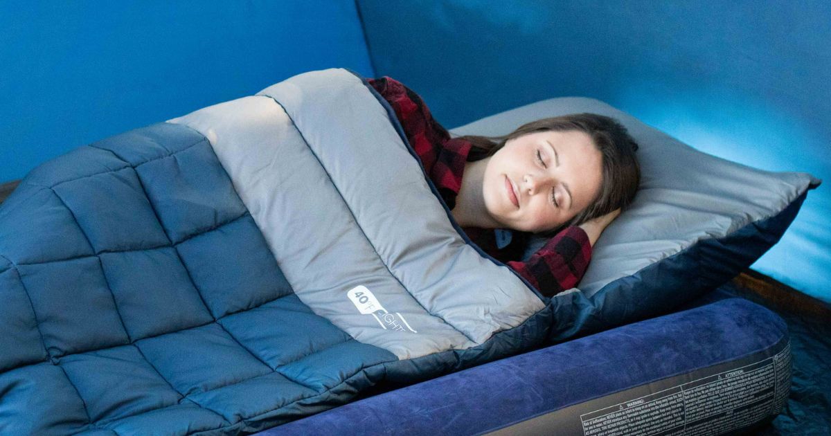 Woman in a tent sleeping in a weighted sleeping bag