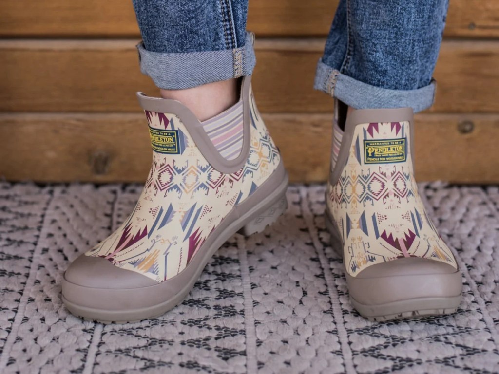 woman wearing pair of short taupe geometric print rain boots