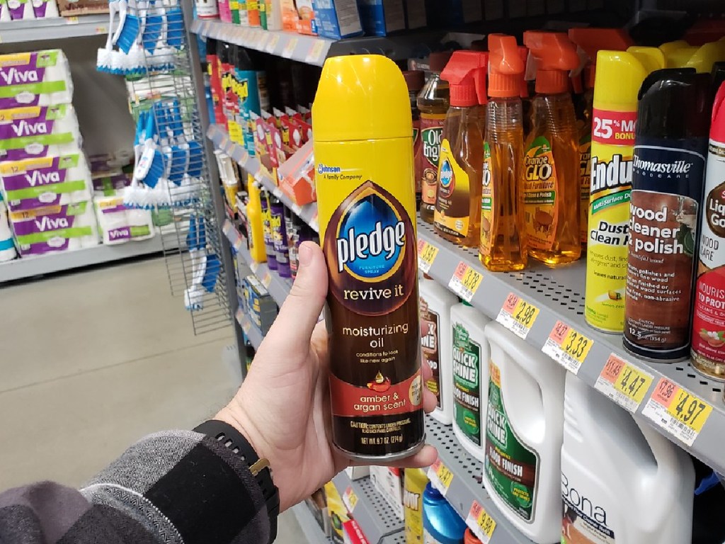 hand holding spray bottle of Pledge Wood Oil in store