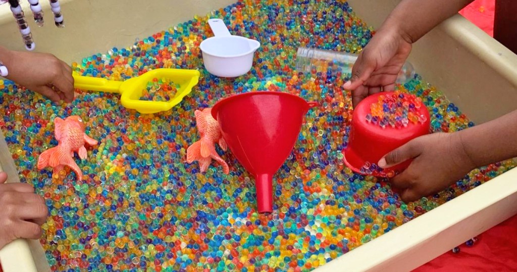 water table filled with rainbow water beads
