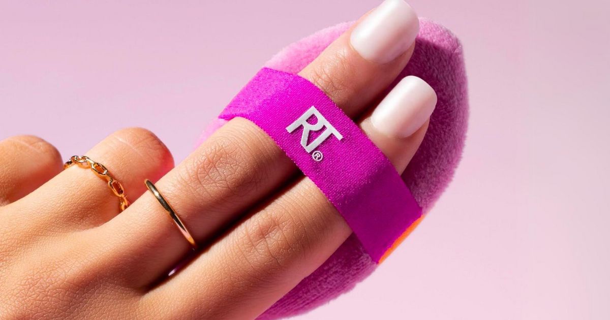 a womans hand with a Real Techniques Miracle 2-In-1 Dual-Sided Powder Puff