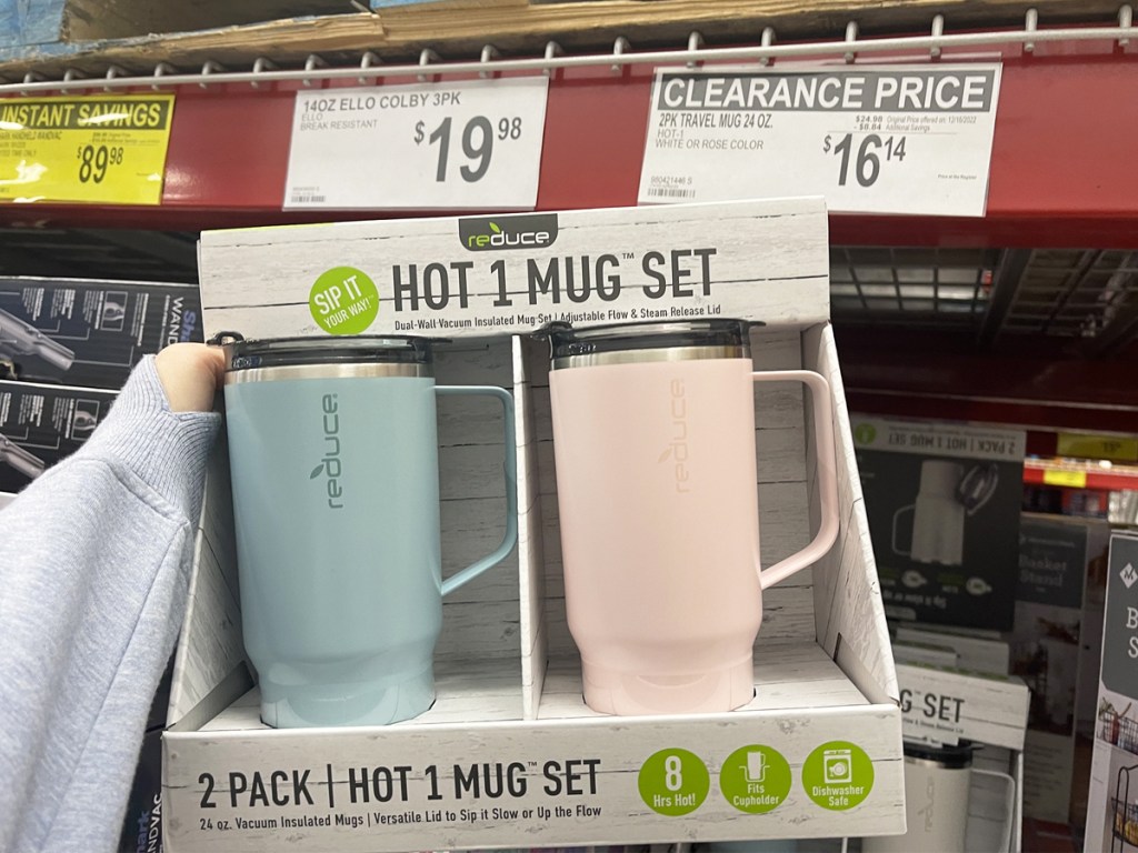 hand holding a 2-pack of travel mugs