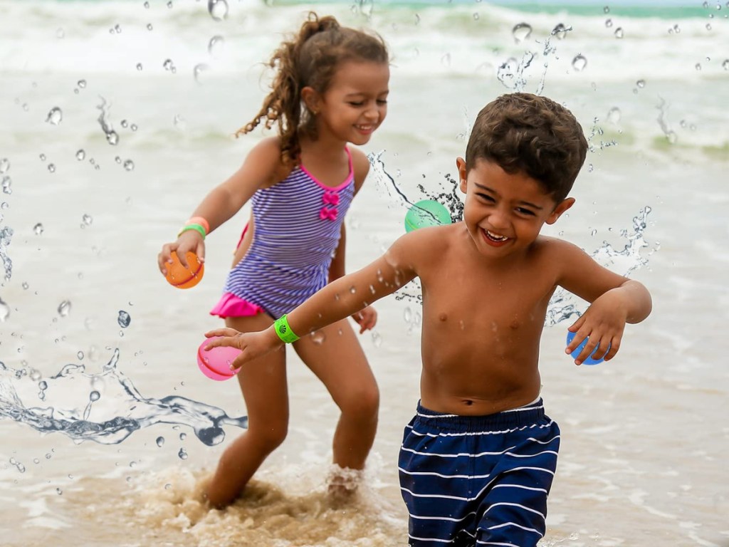 boy and girl playing with water balloon balls