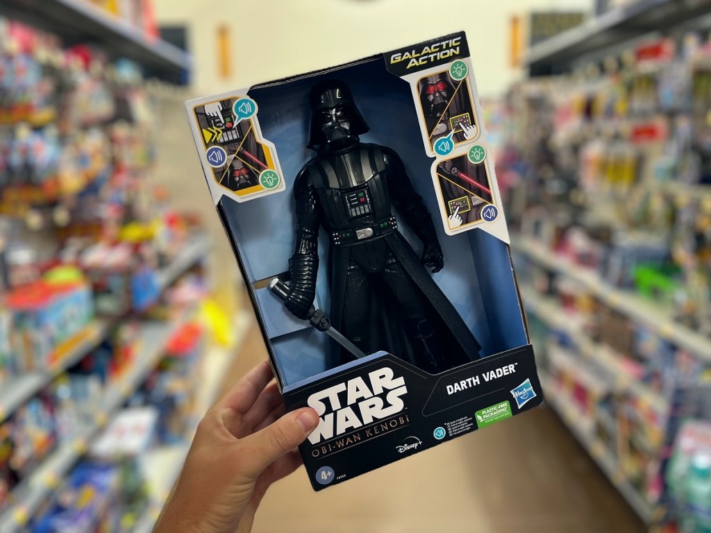 holding a boxed Darth Vader Action Figure