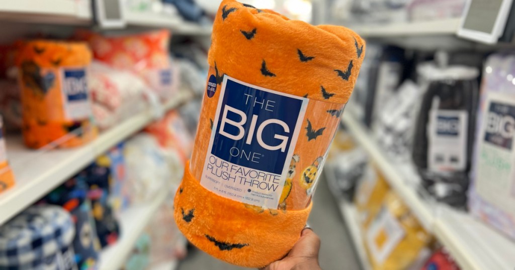 hand holding Halloween print plush throw blanket in store