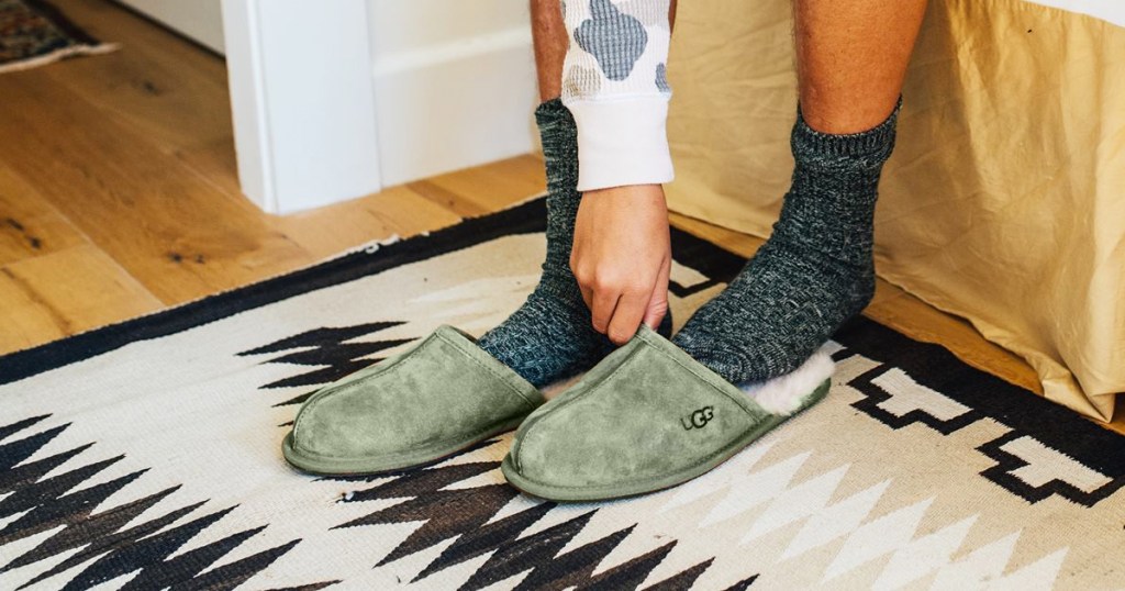 man putting on a pair of green ugg slippers