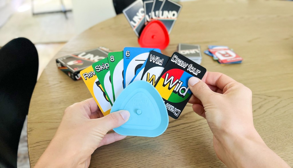 hand pulling out draw four card from uno card game