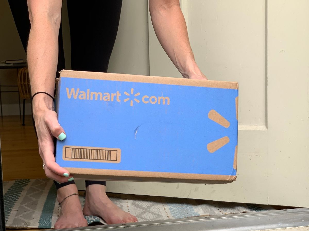 woman picking up a walmart delivery box off her porch
