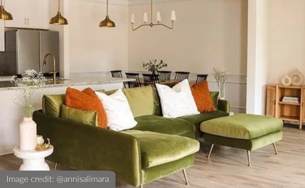 green velvet couch with gold legs in styled living room kitchen area