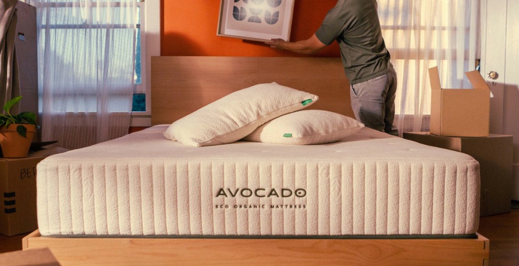 avocado mattress in bedroom with man hanging picture
