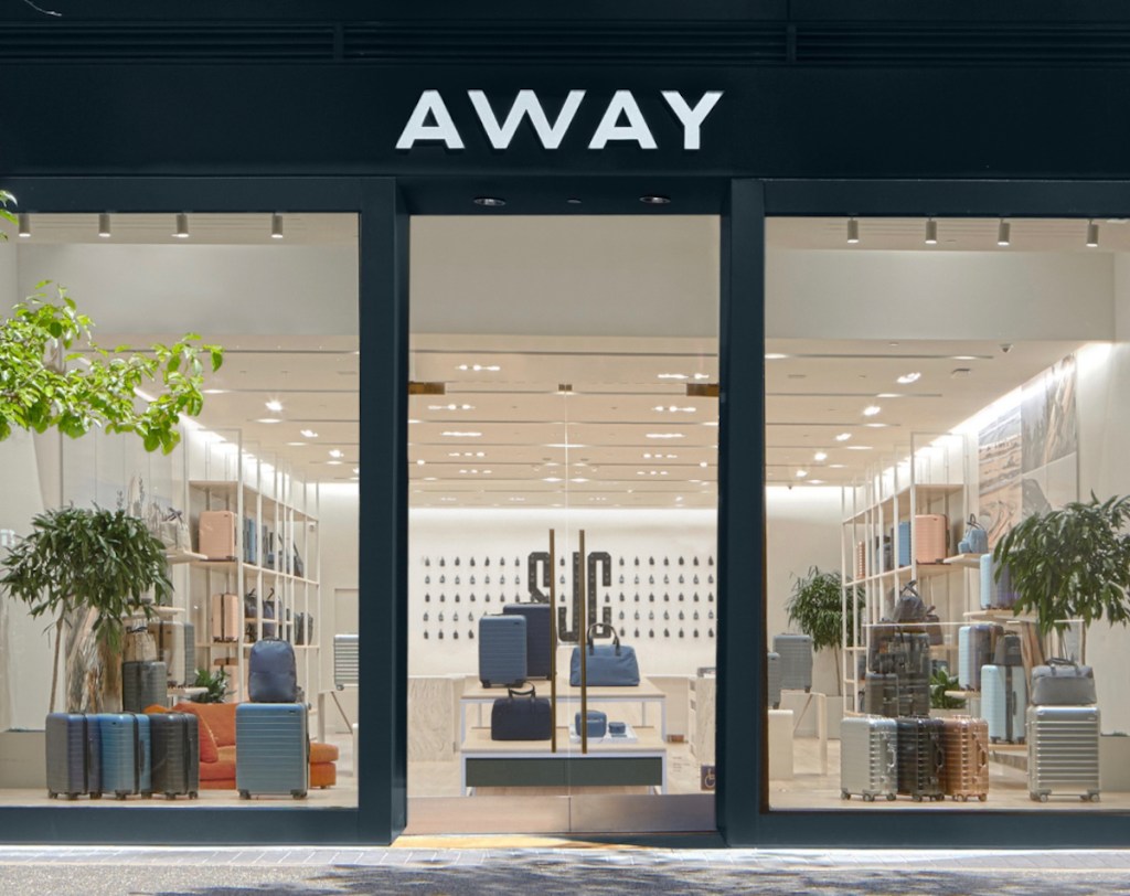 away luggage storefront with large windows and brightly lit store with suitcases inside