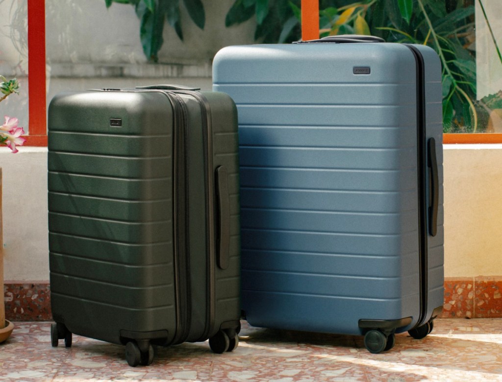dark green and blue away luggage suitcases on tile floor