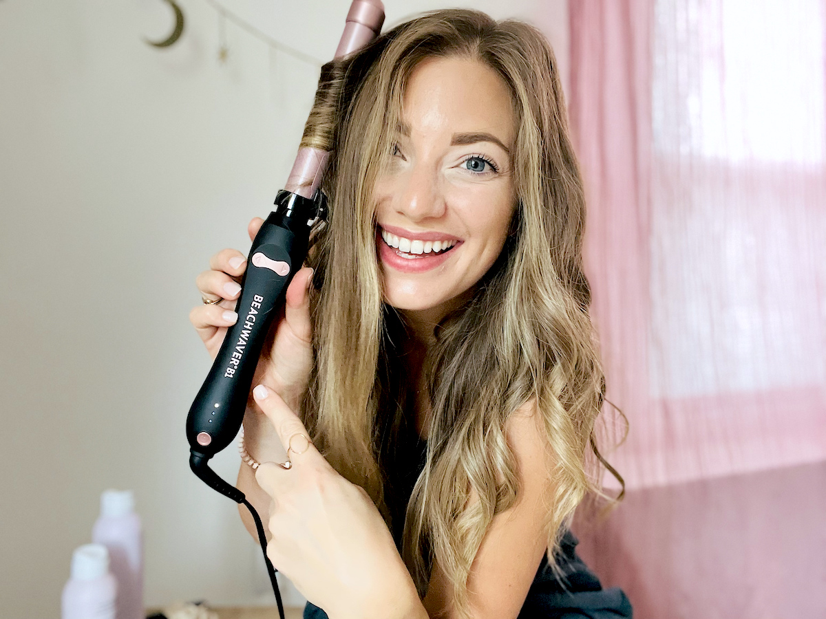 woman pointing to curling iron in hair 