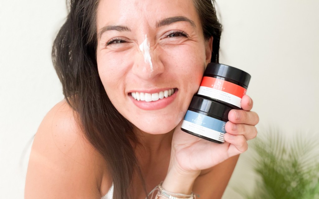 woman holding face creams
