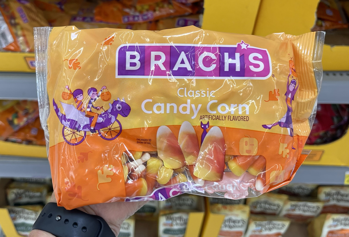 a hand holding a bag of brach's candy corn