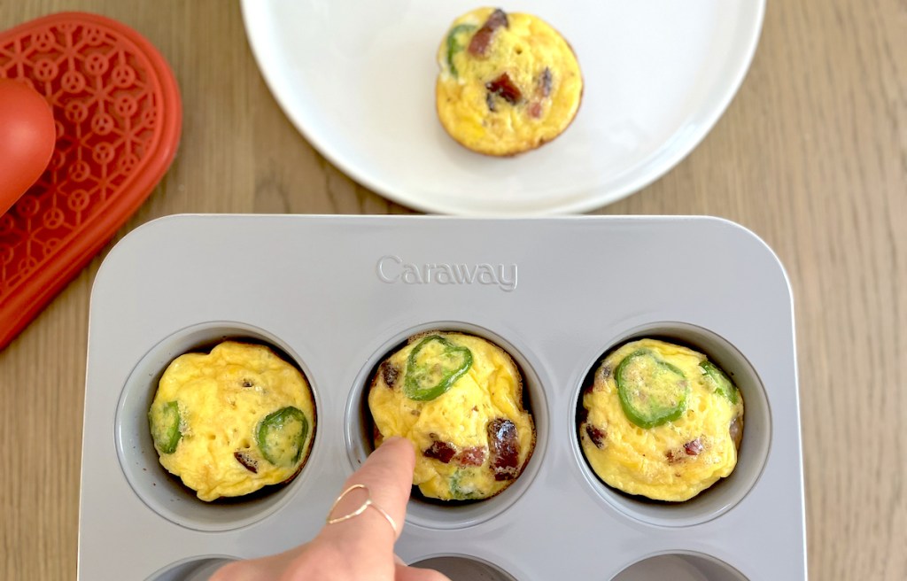 finger poking at frittata in muffin pan
