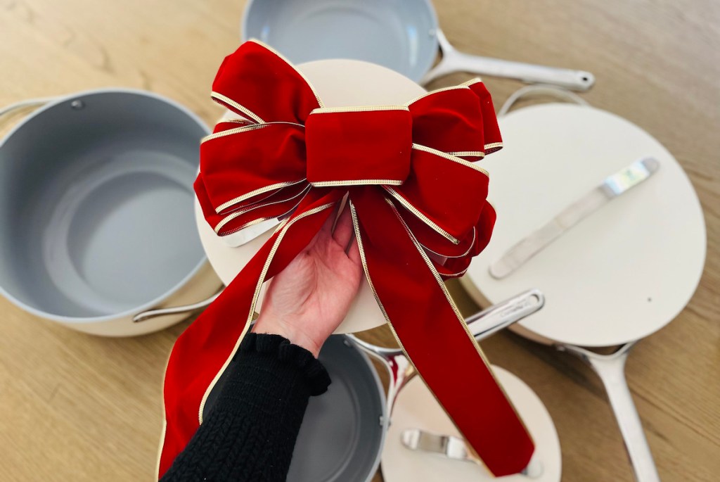 hand holding pan with big red bow 