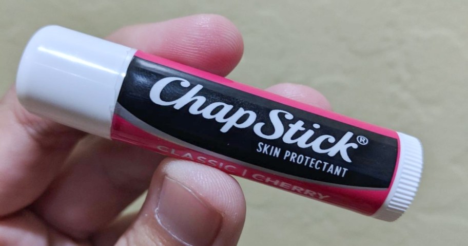 holding a tube of chapstick
