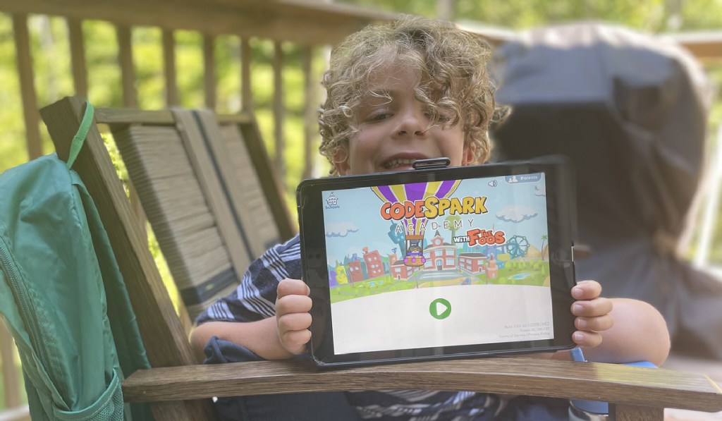 child showing off education game on a tablet