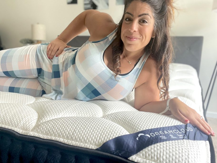 woman laying on dreamcloud mattress smiling