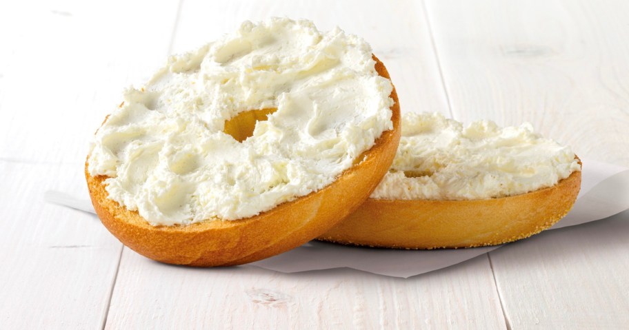 einstien bros bagel with schmear on napkin sitting on table