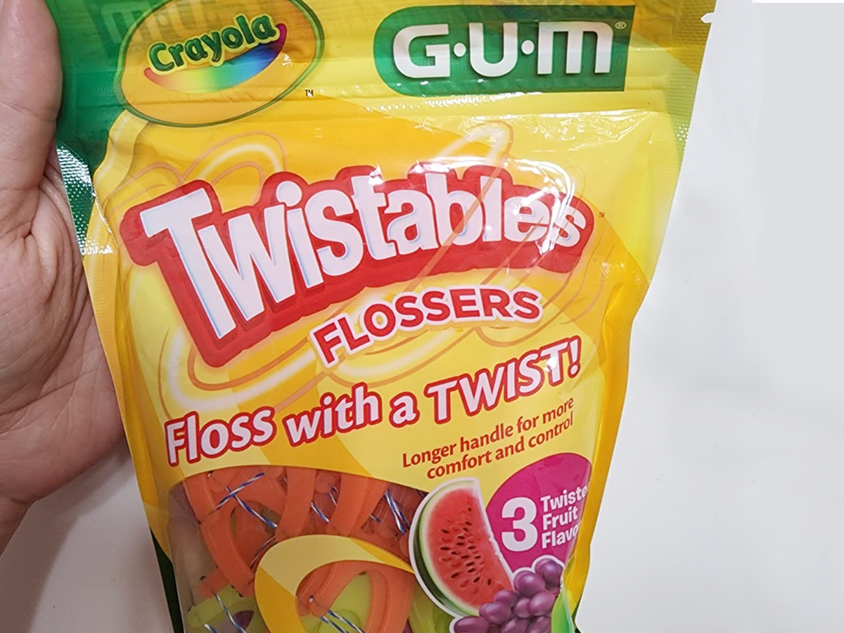 gum twistables flossers in hand