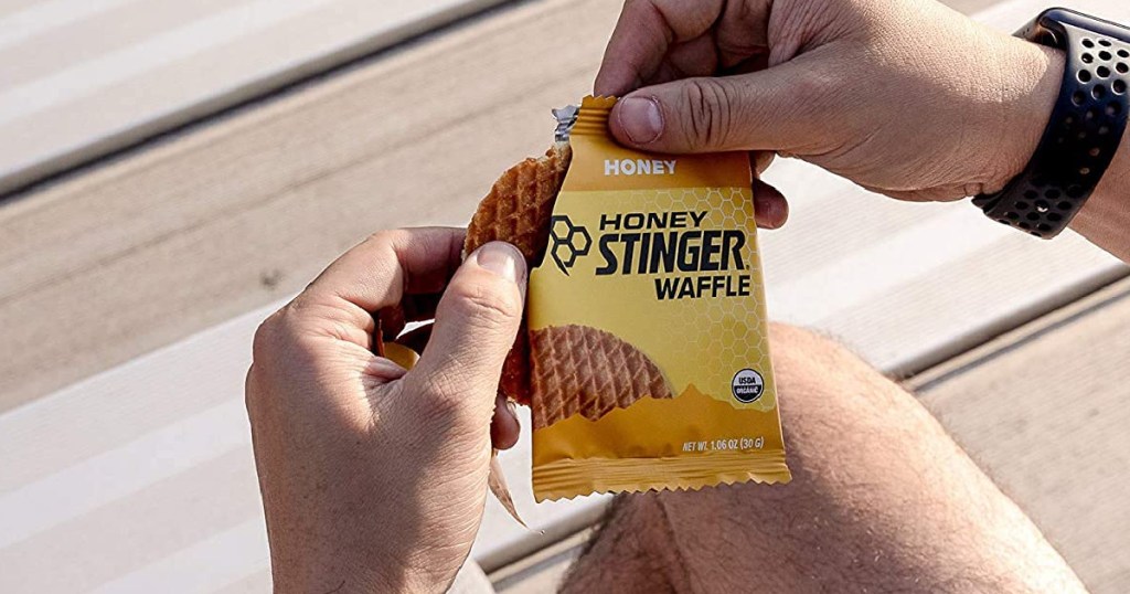 hand tearing open a package of honey stinger waffles