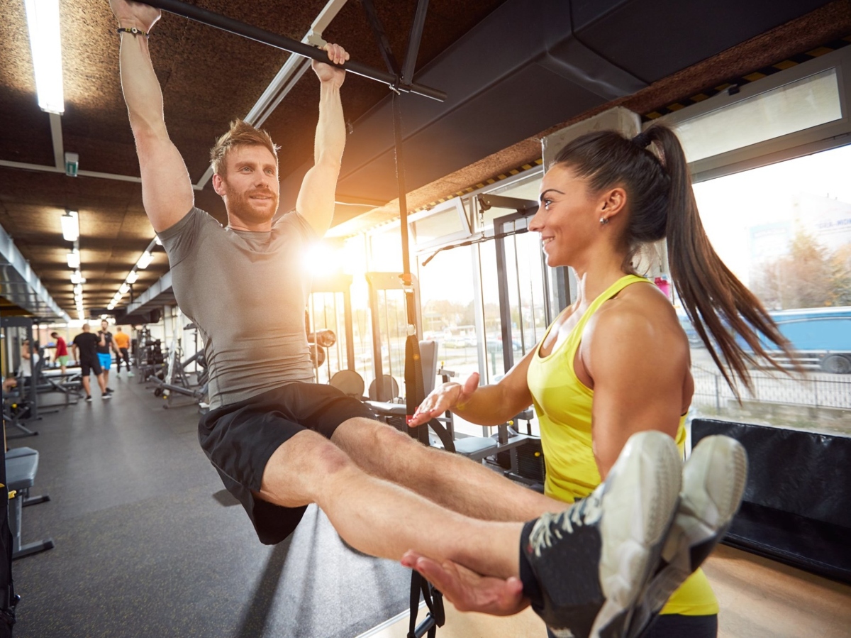 man working with personal trainer at gym