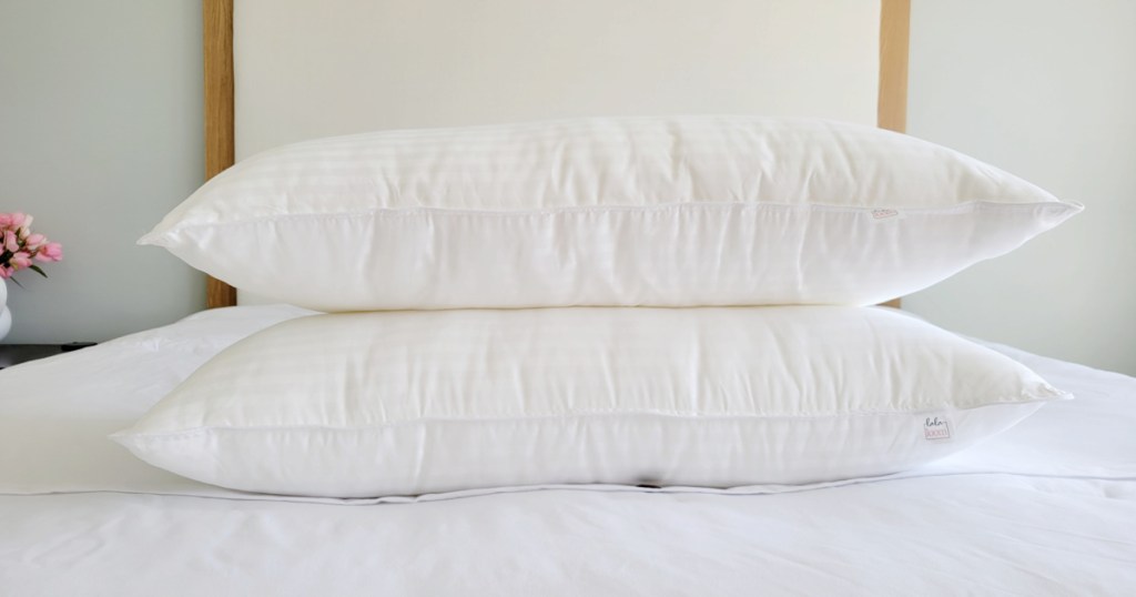 two pillows laying on empty mattress