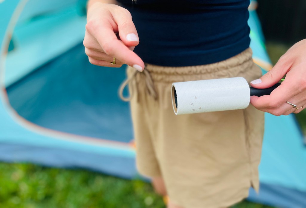 hand holding a lint roller with bugs on it for camping ideas and camping hacks