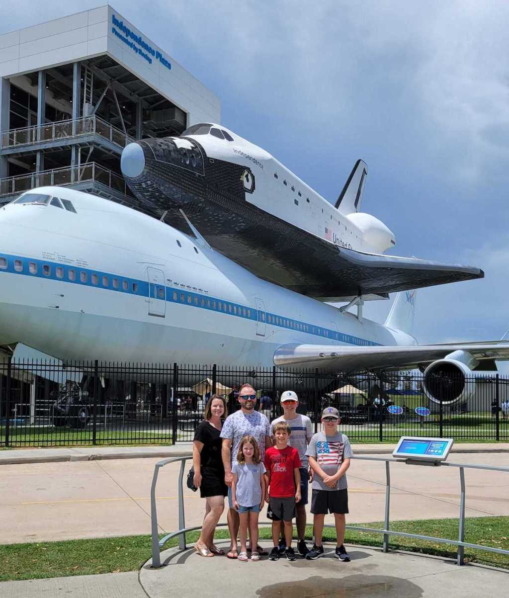 family standing in front of spaceship outside